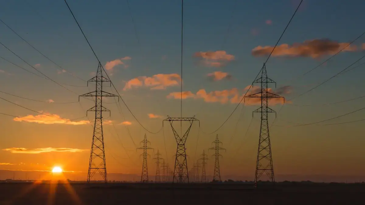 Electricity pylons silhouetted against a sunset