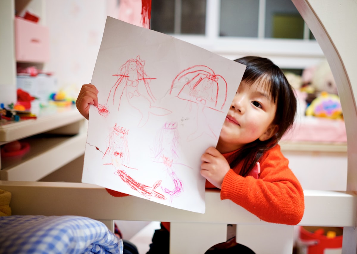 A child holding up a drawing
