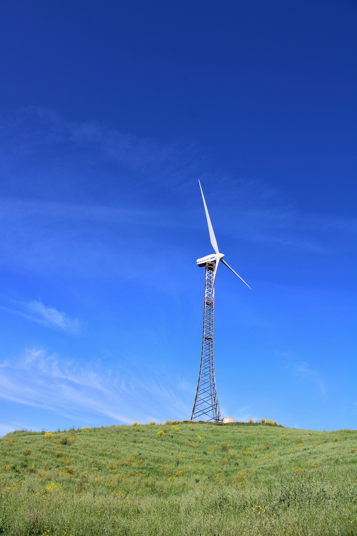 A wind turbine on a grassy hill
