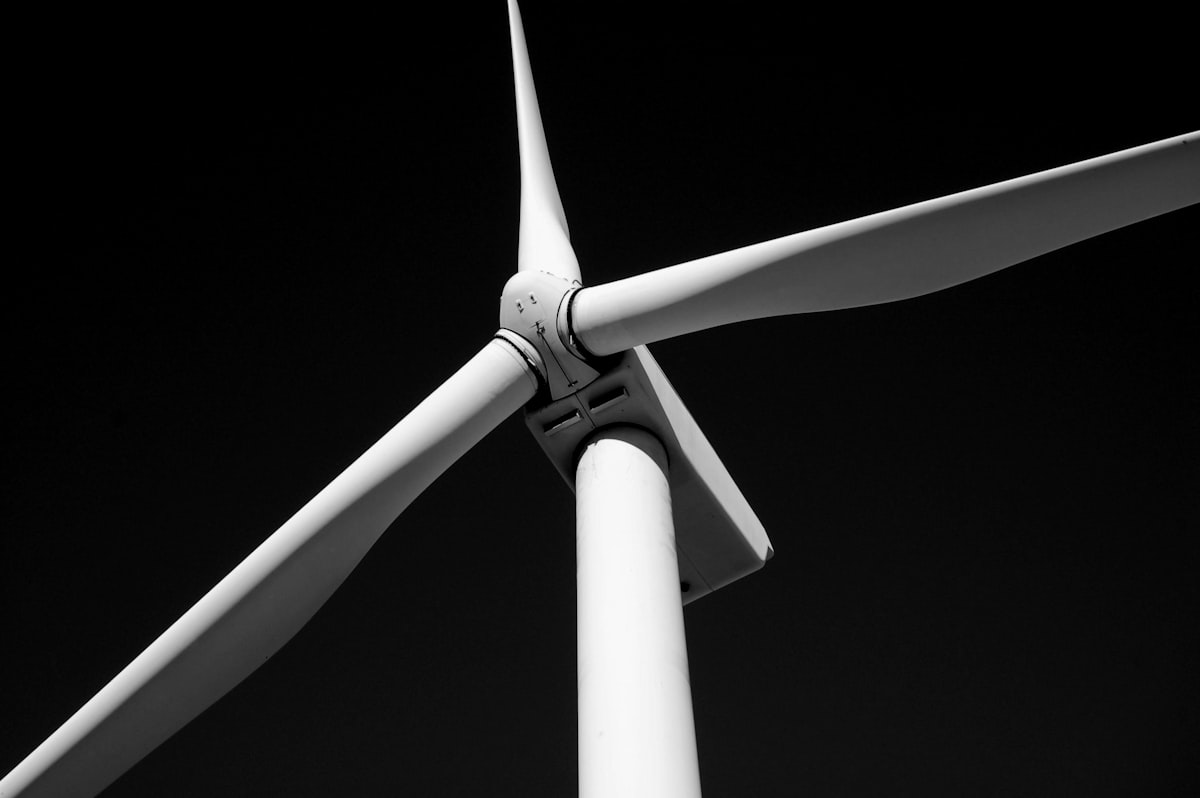A wind turbine seen close up against a dark sky