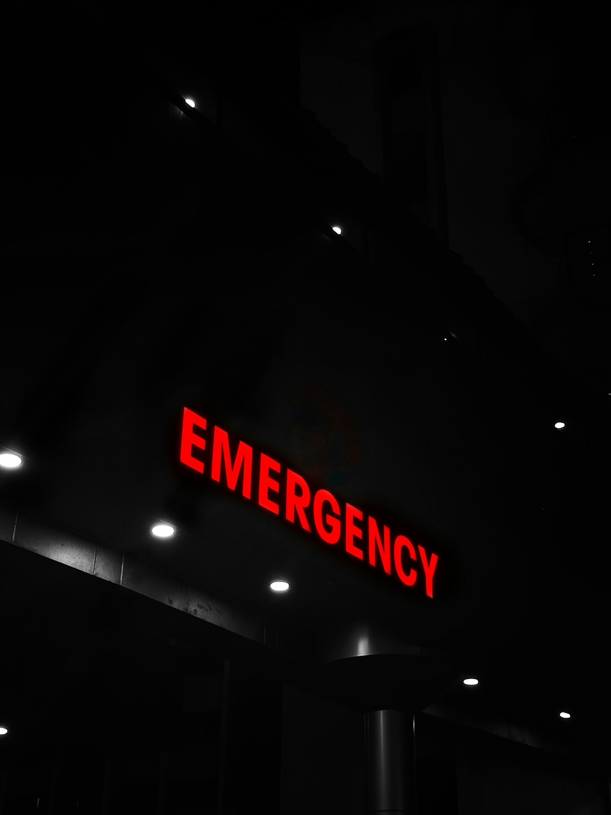 A hospital emergency sign lit up at night