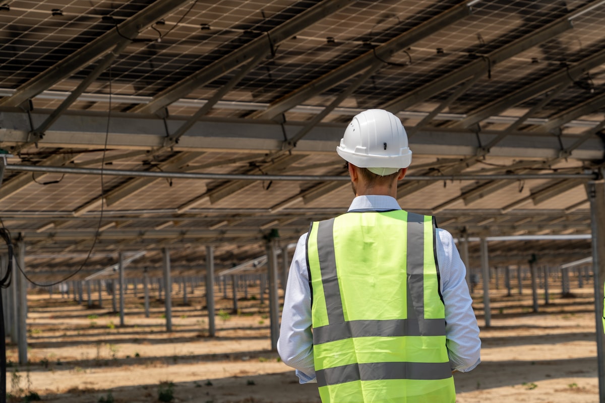 An engineer in a hard hat at a solar farm